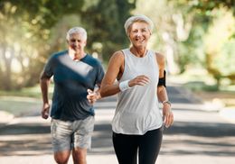 A man and a woman are jogging in a park.