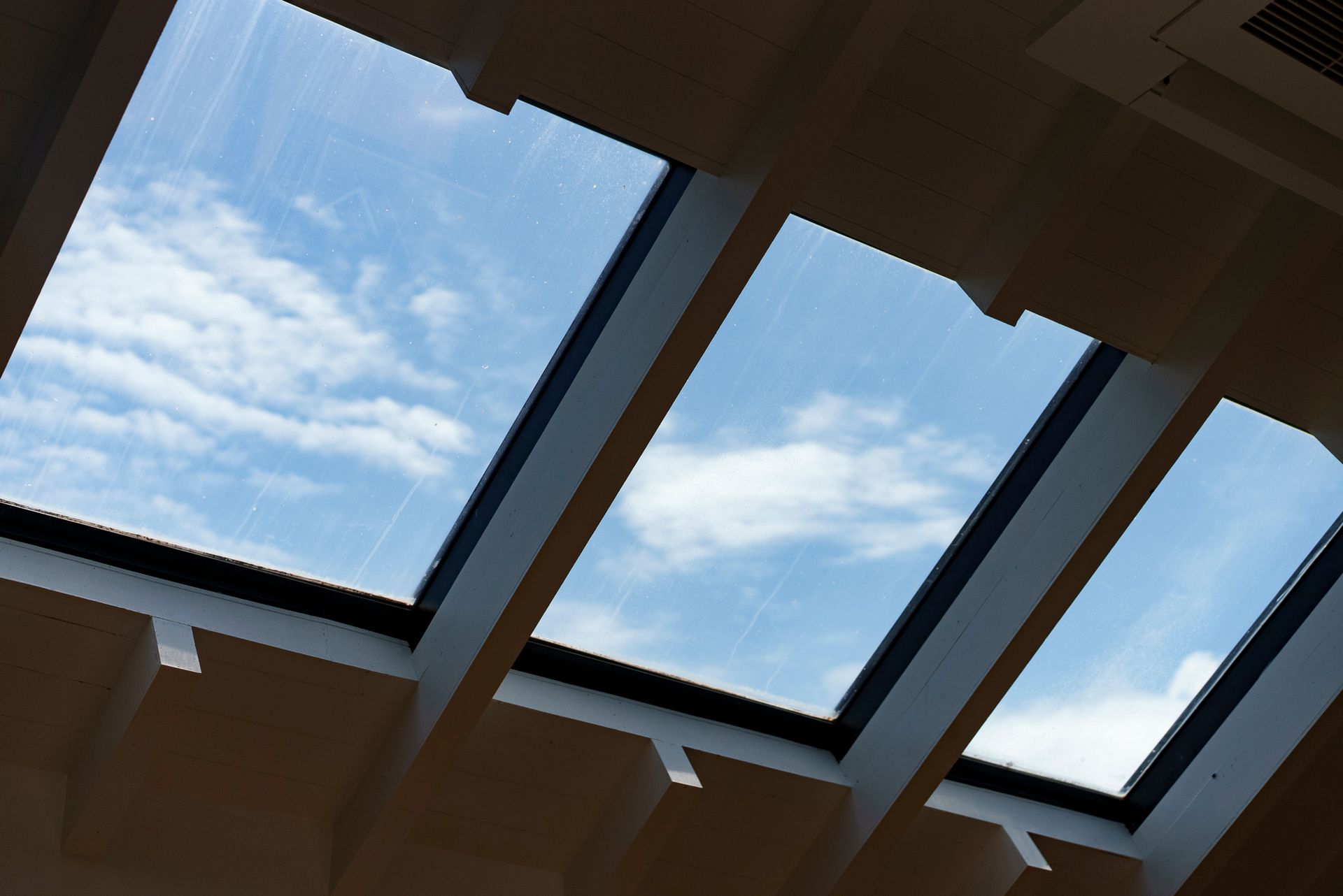 Looking up at a blue sky through a skylight