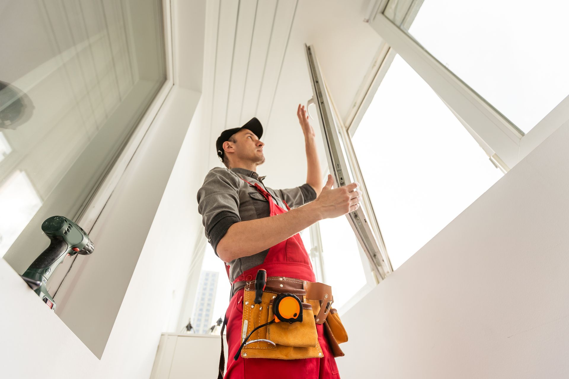 A male professional changes rubber seal gasket in PVC windows, as part of window service.