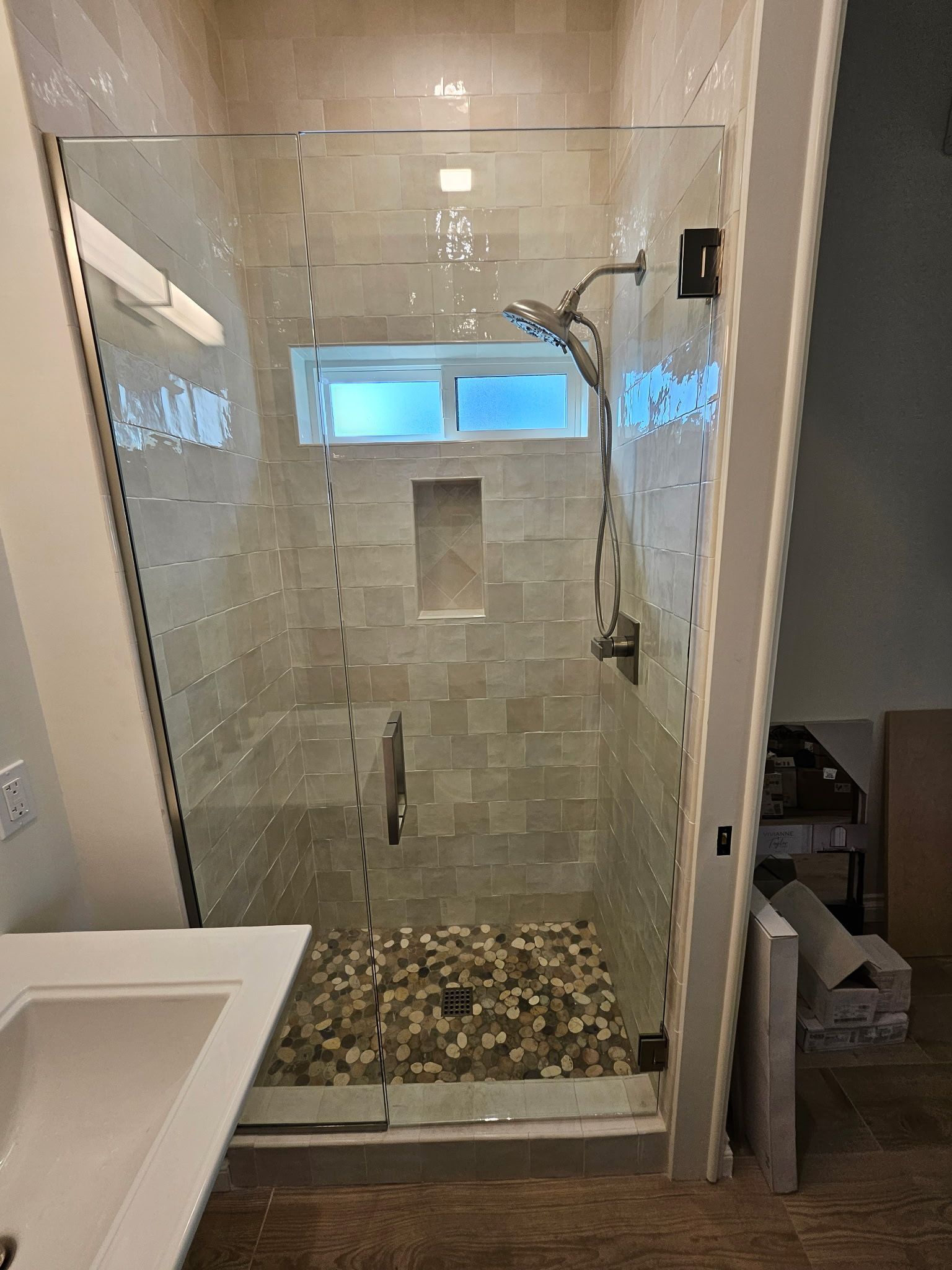 A bathroom with a walk in shower and a sink.