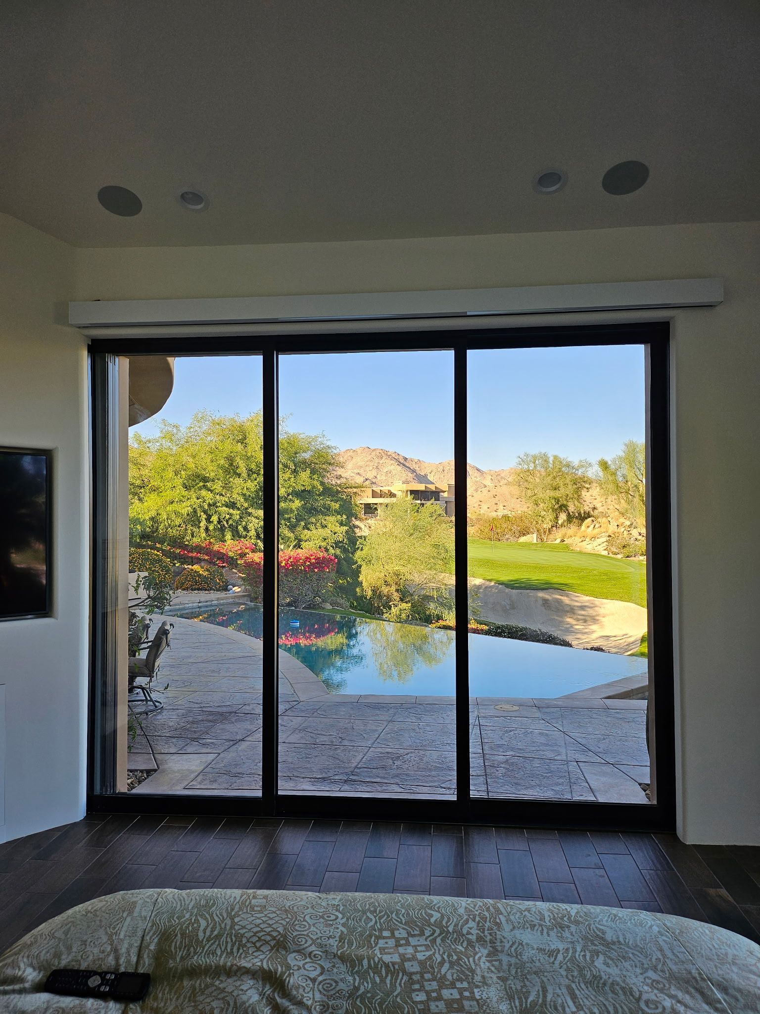 A bedroom with a sliding glass door leading to a pool.