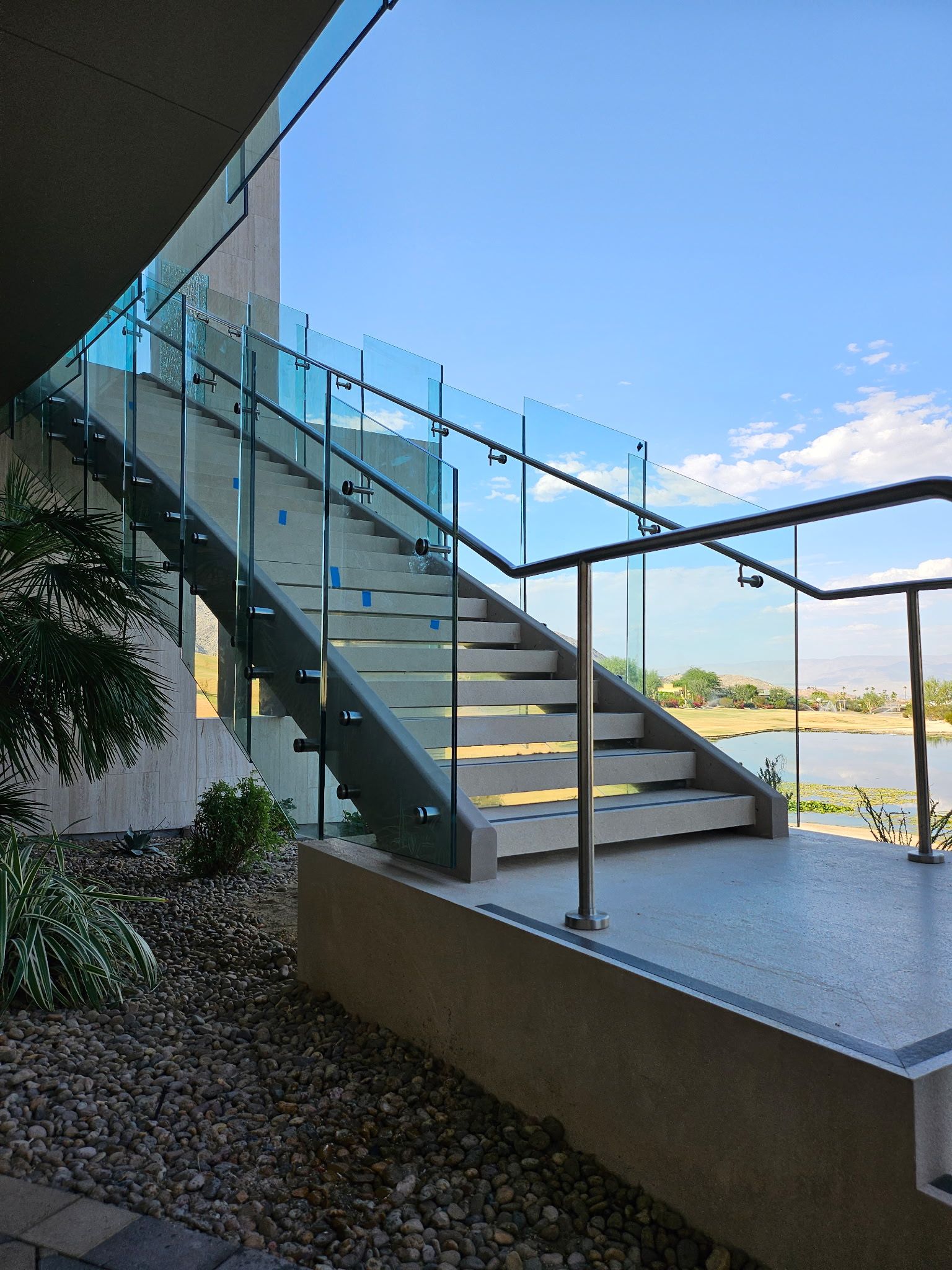 A set of stairs with a glass railing leading up to a balcony.