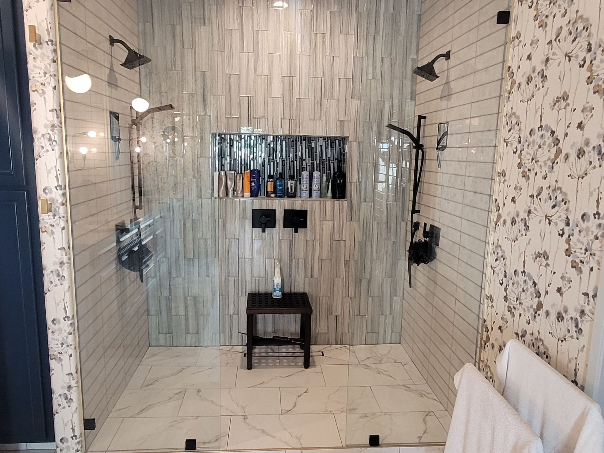 A bathroom with a walk in shower and two shower heads.