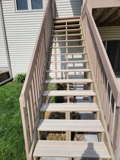 A set of wooden stairs leading up to a deck.