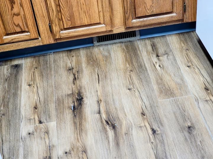 A kitchen with wooden cabinets and a wooden floor.