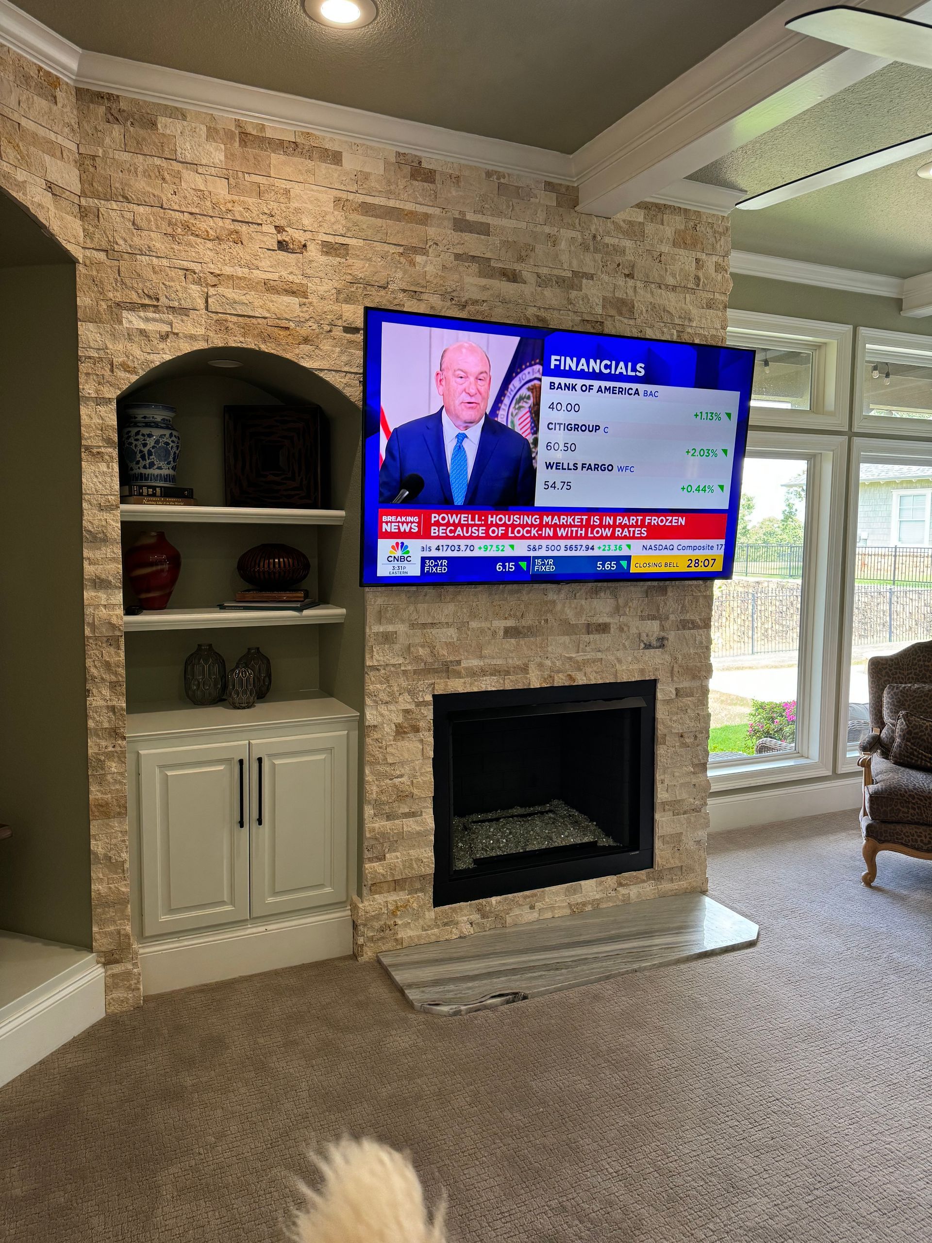 A living room with a fireplace and a flat screen tv on the wall.