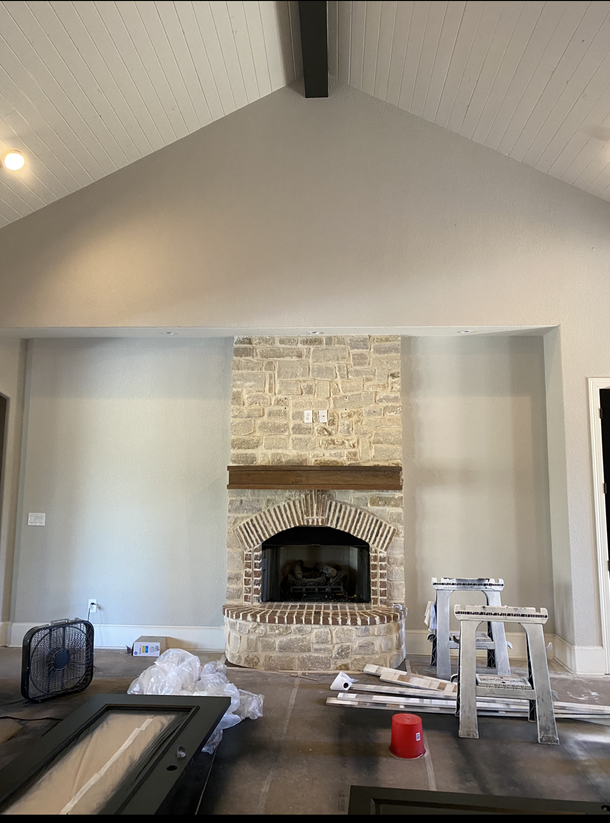 A living room with a brick fireplace and a vaulted ceiling