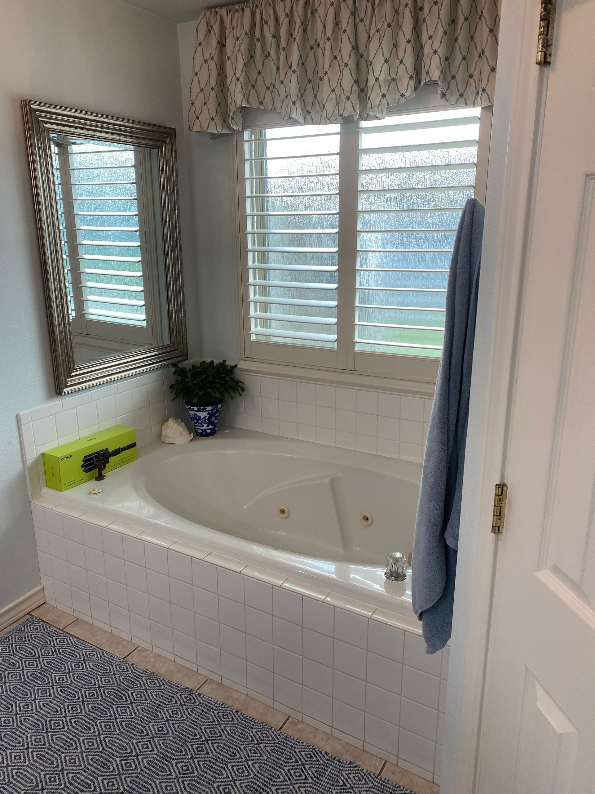 A bathroom with a jacuzzi tub and a mirror.