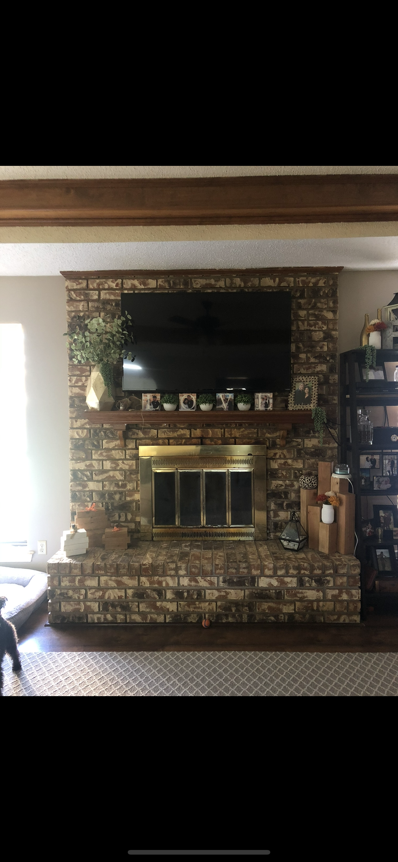 A living room with a fireplace and a flat screen tv on the wall.