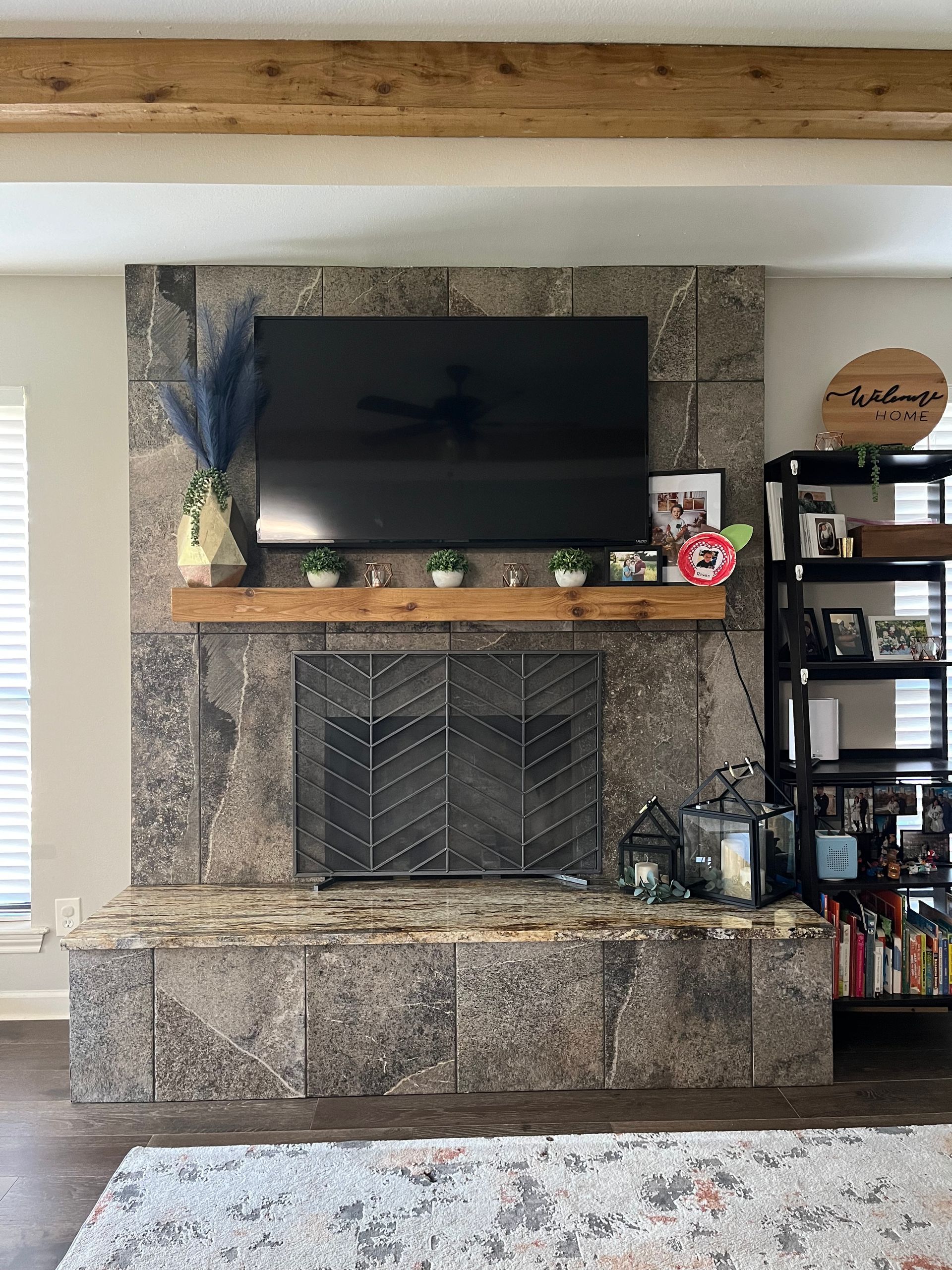 A living room with a fireplace and a flat screen tv on the wall.