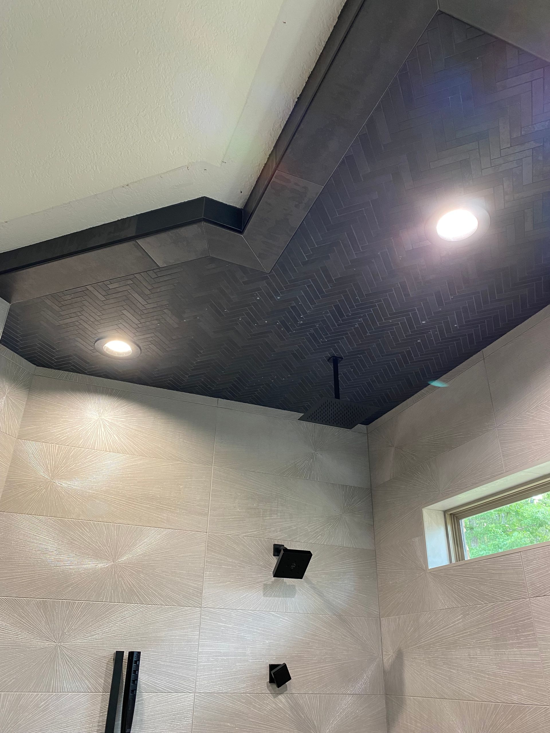 A shower with a black ceiling and a black shower head.