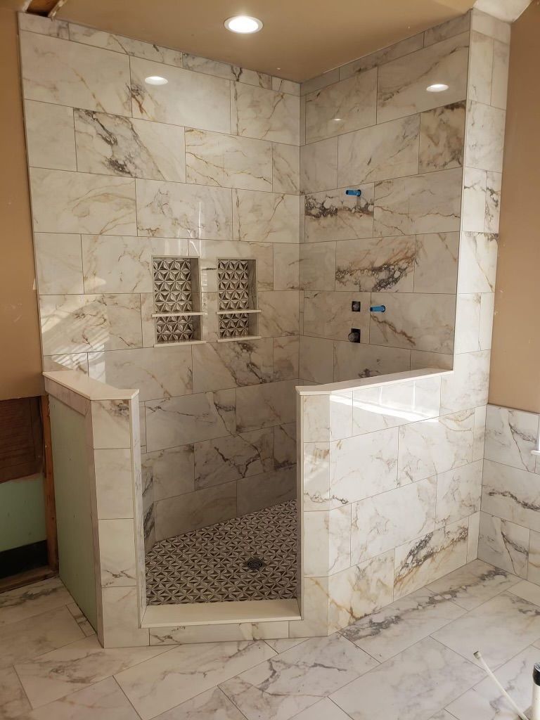 A bathroom with a walk in shower and a tub.