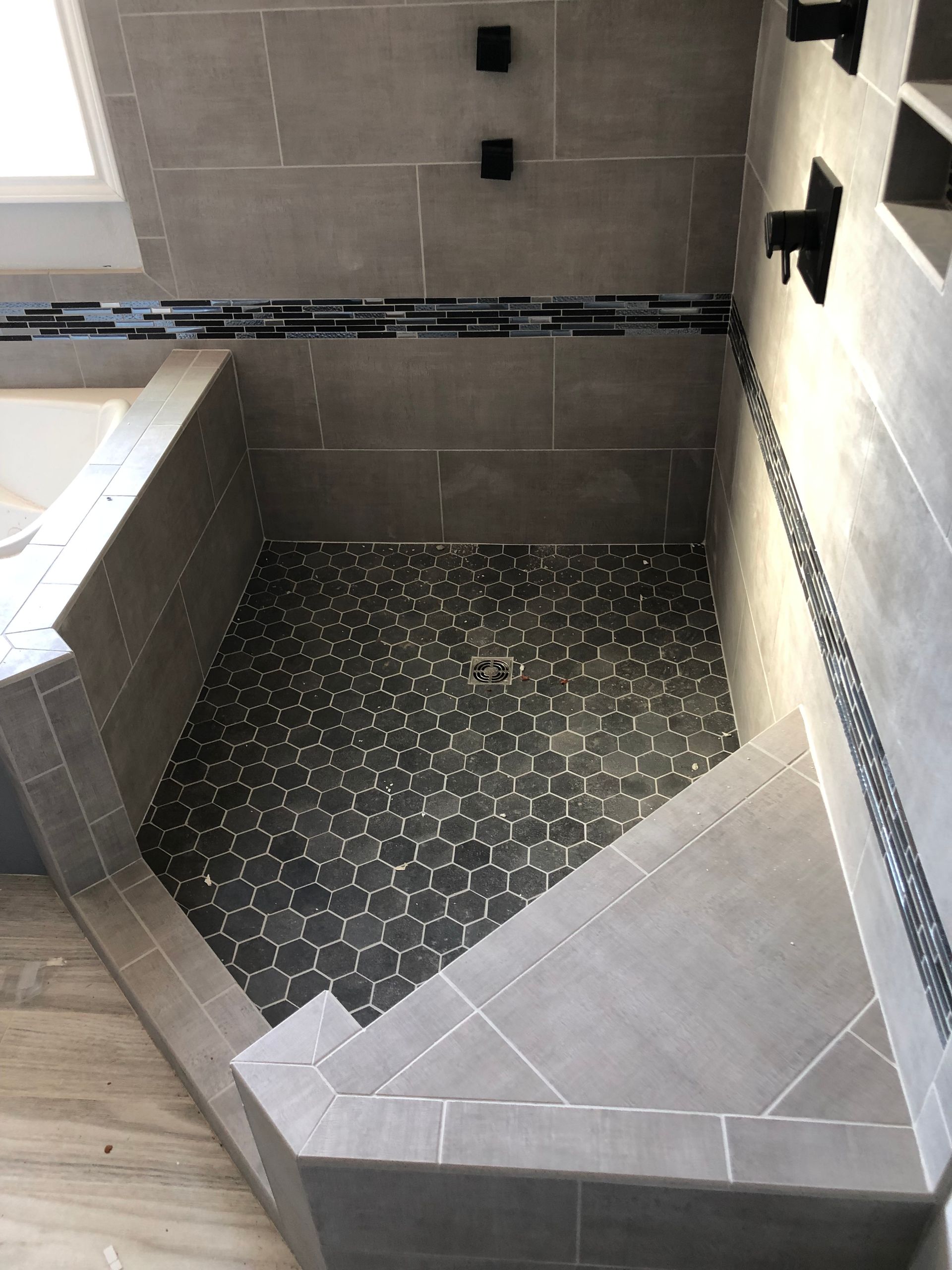 A bathroom with a walk in shower and a bathtub.