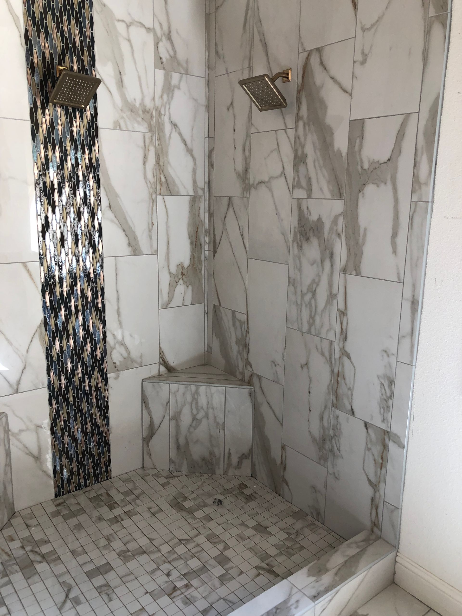 A shower with marble tiles and a shower head