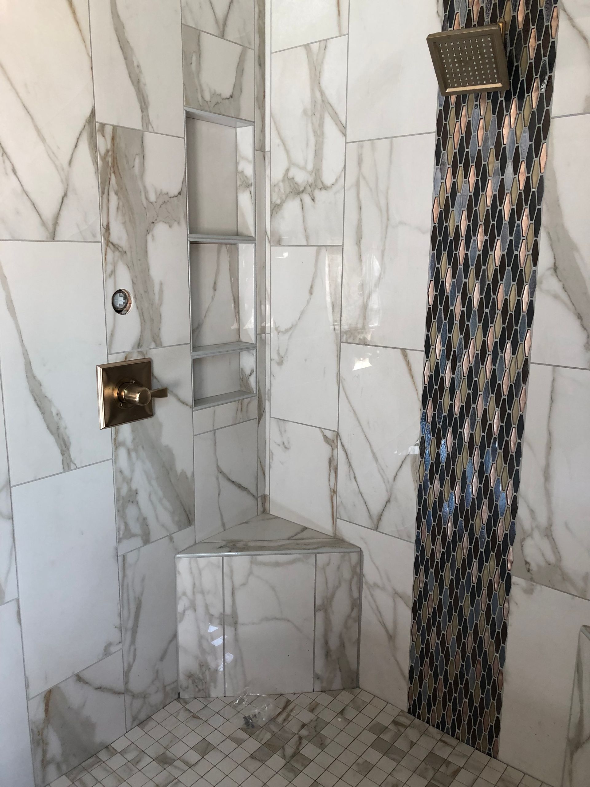 A bathroom with marble tiles and a walk in shower