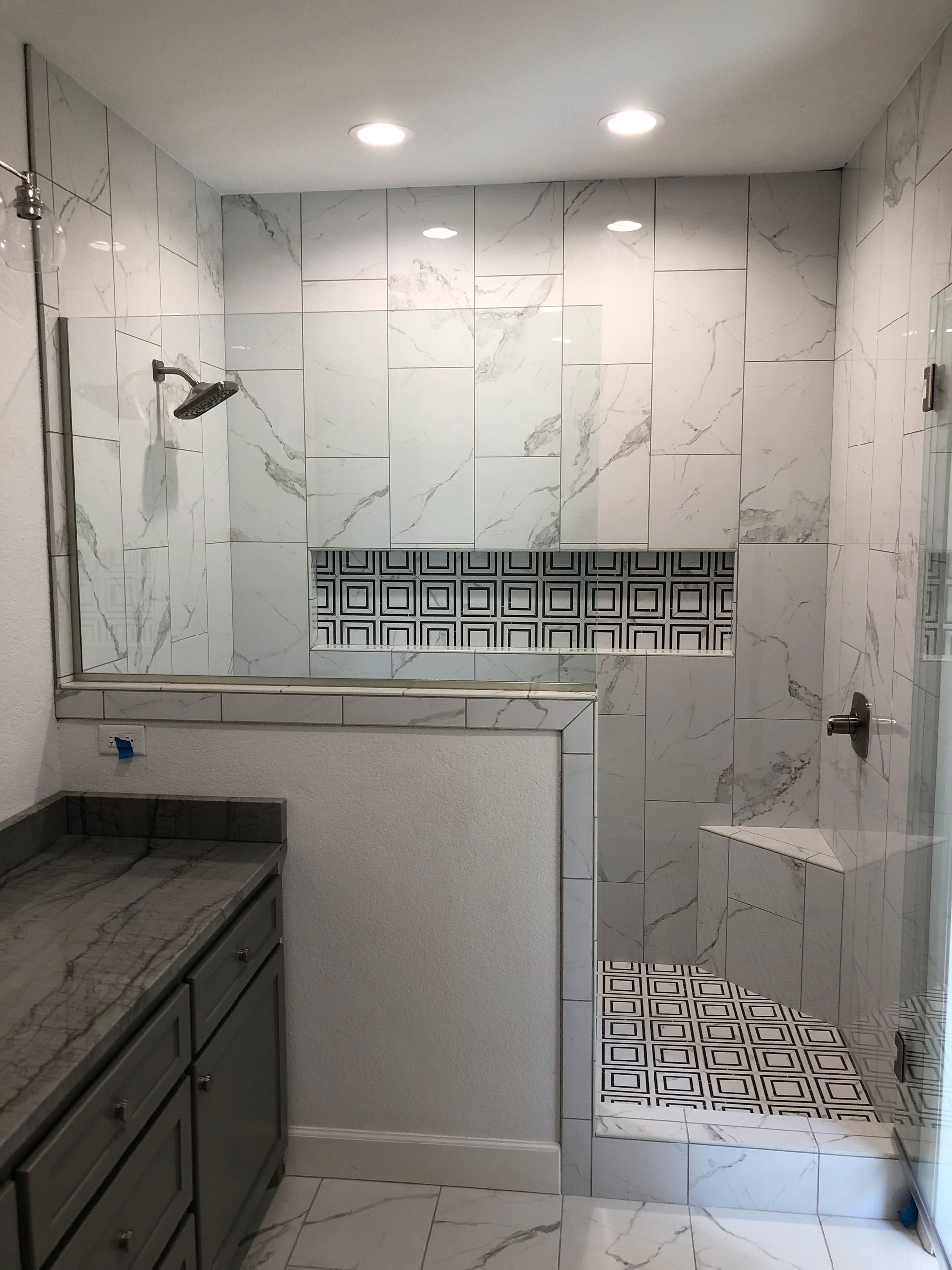 A bathroom with a walk in shower and a sink.