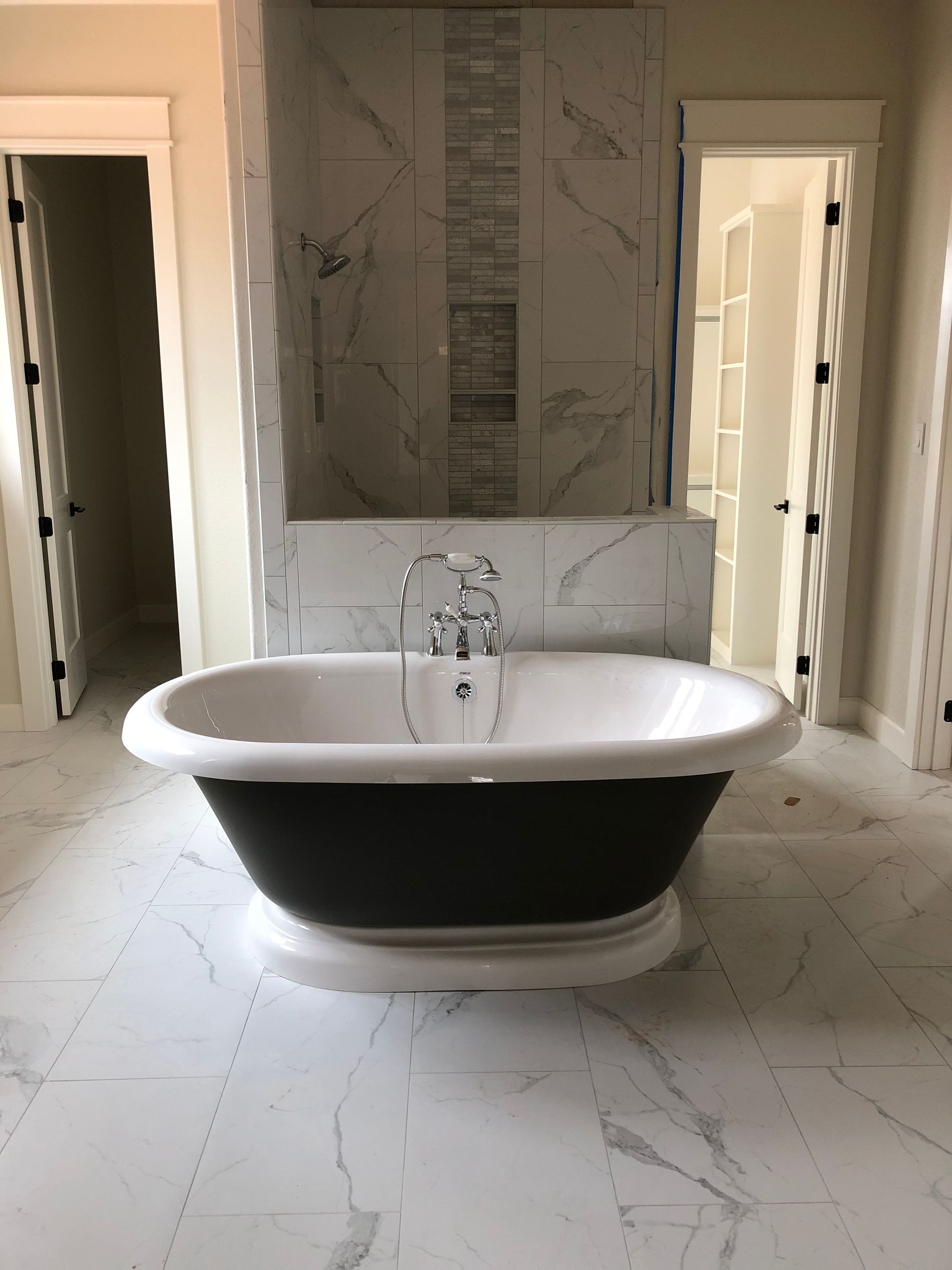 A black and white bathtub is sitting in a bathroom.
