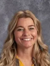 A woman with long blonde hair is smiling for the camera.
