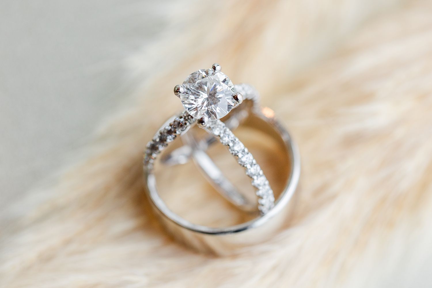 A close up of a wedding ring and engagement ring on a table.