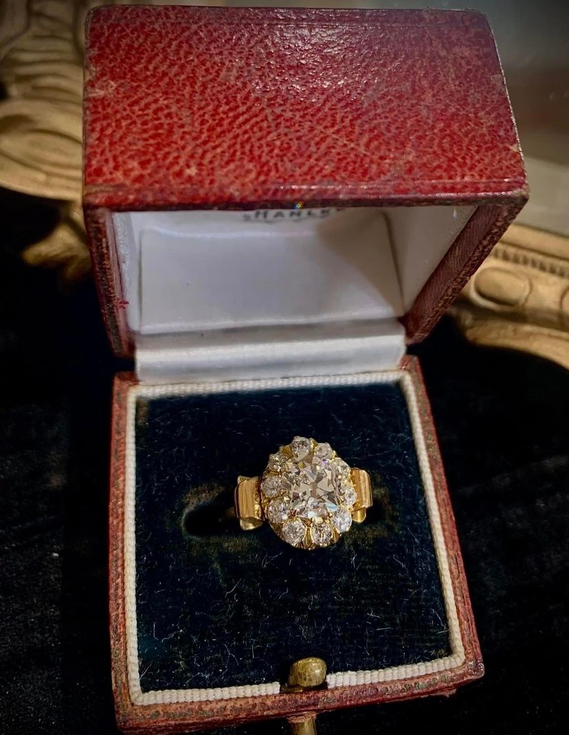 A ring is sitting in a red box on a table.