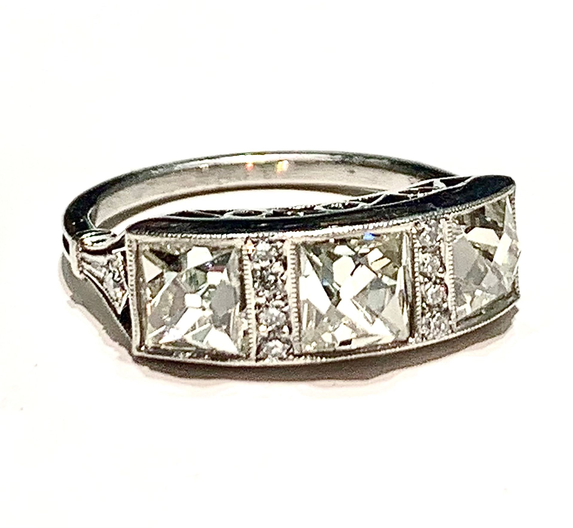A close up of a diamond ring on a white background.