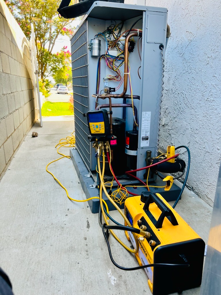 An air conditioner is being serviced by a technician