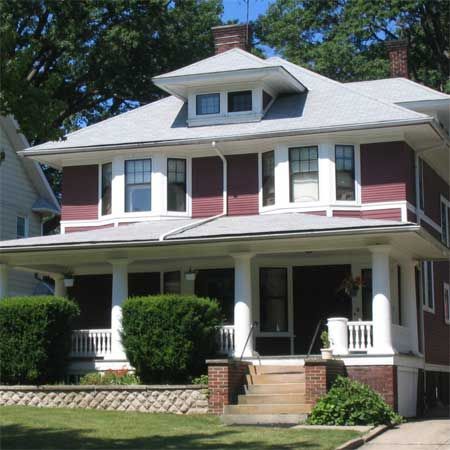 A red house with white trim and a gray roof