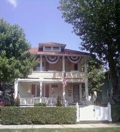 A large house with a porch and a flag on it
