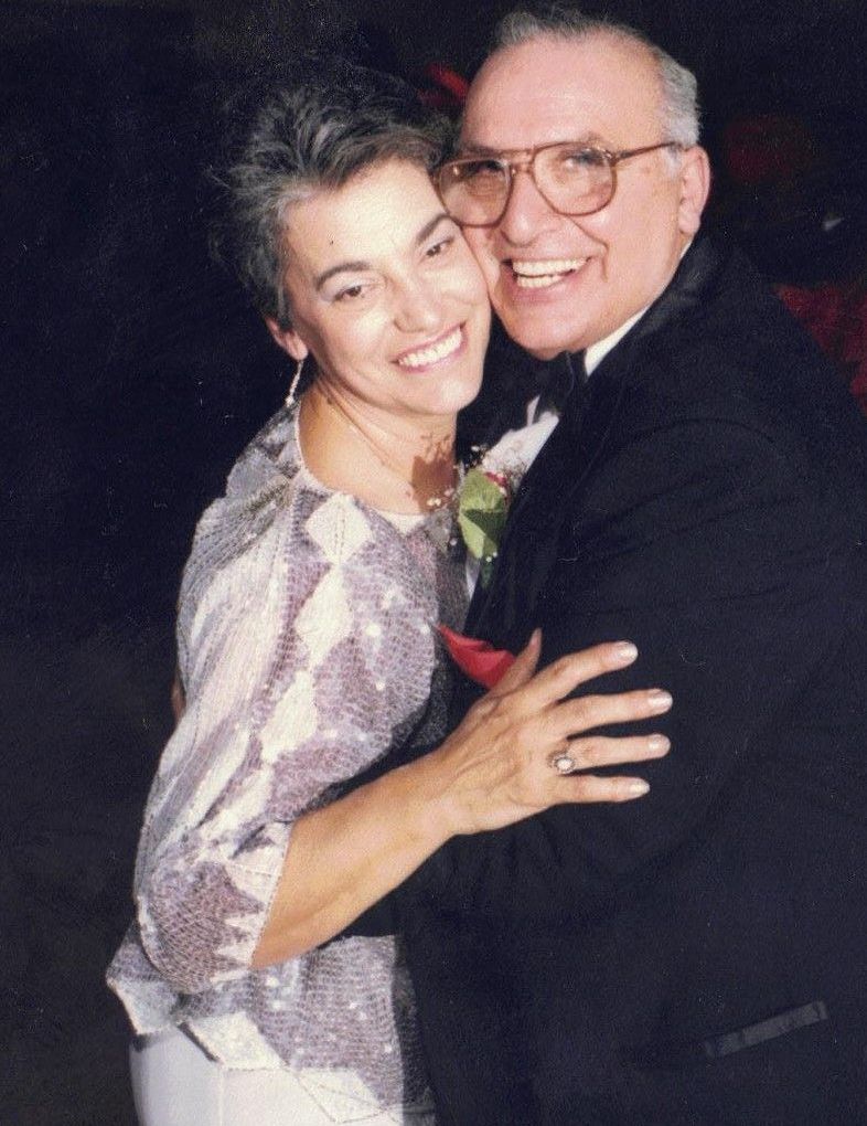 A man and woman are hugging and smiling for the camera