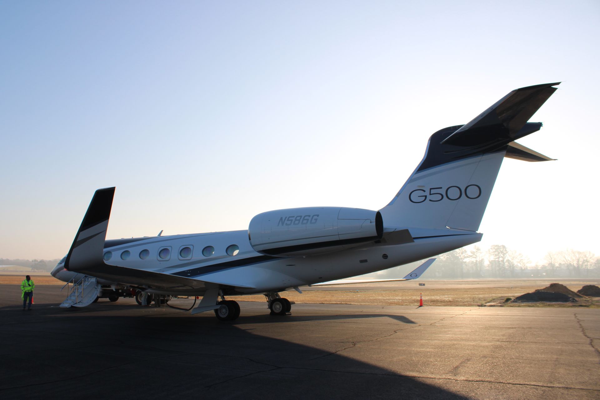 Private jet parked on a runway at sunset, with “G500” visible on the tail.