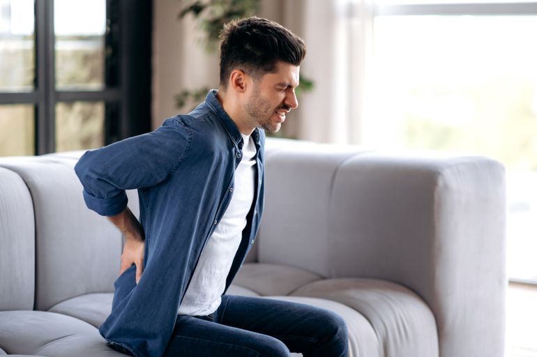 Man holding low back in pain