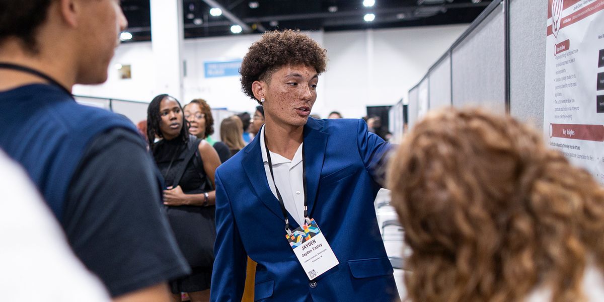 Person presenting poster at APA 2025
