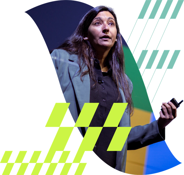 Woman speaking on stage with a microphone, framed by teal, green, and blue geometric shapes.