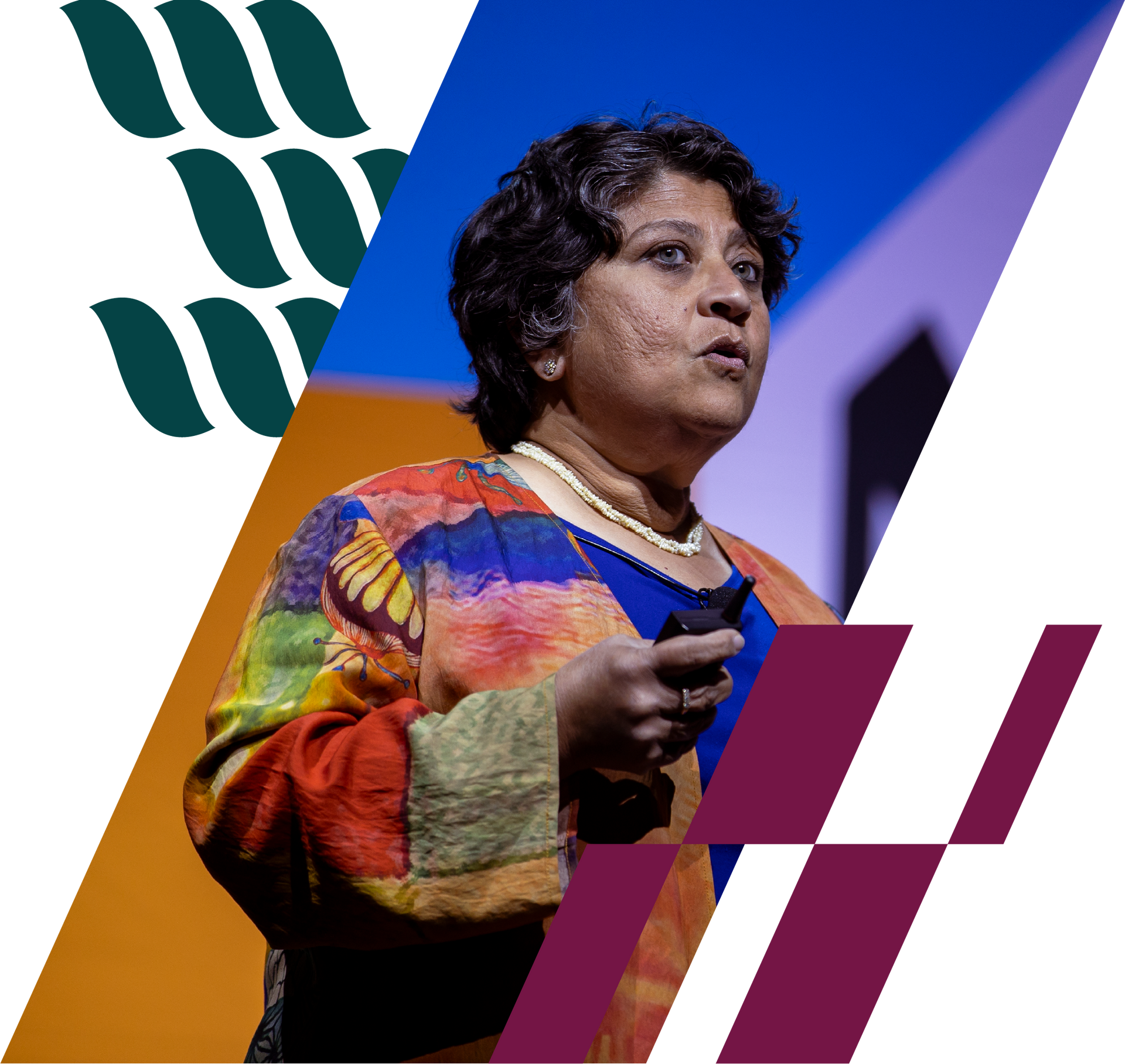 Speaker on stage in a colorful top, holding a microphone against a geometric backdrop