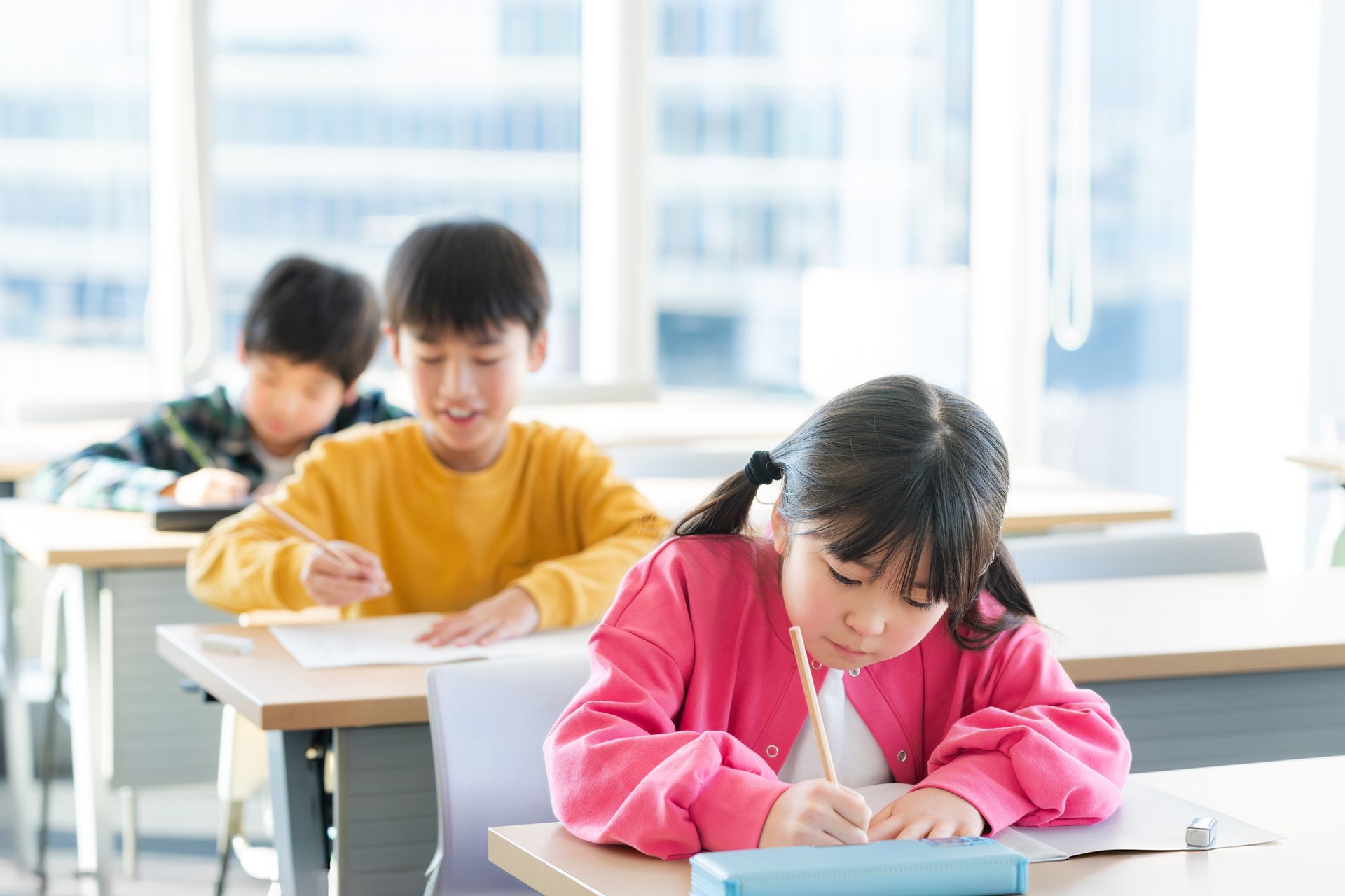 A group of children are sitting at desks in a classroom.