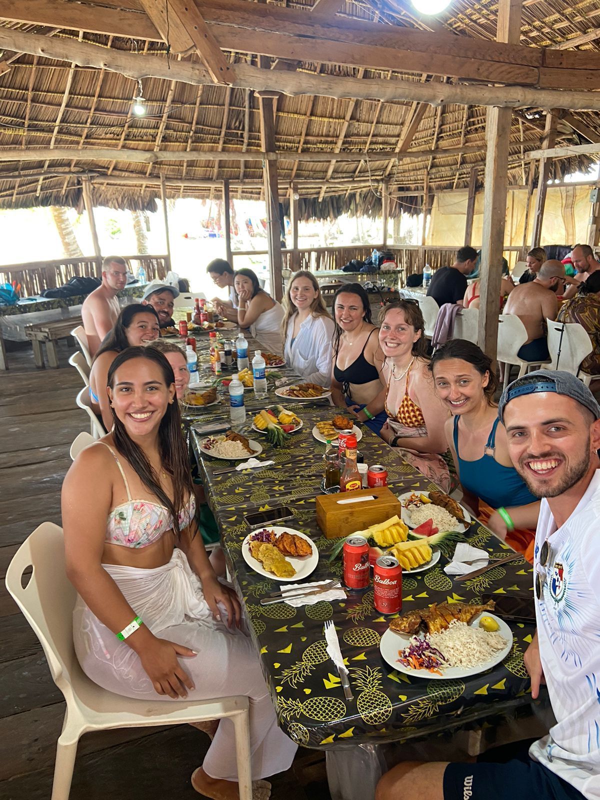 A group of people are sitting at a long table eating food.