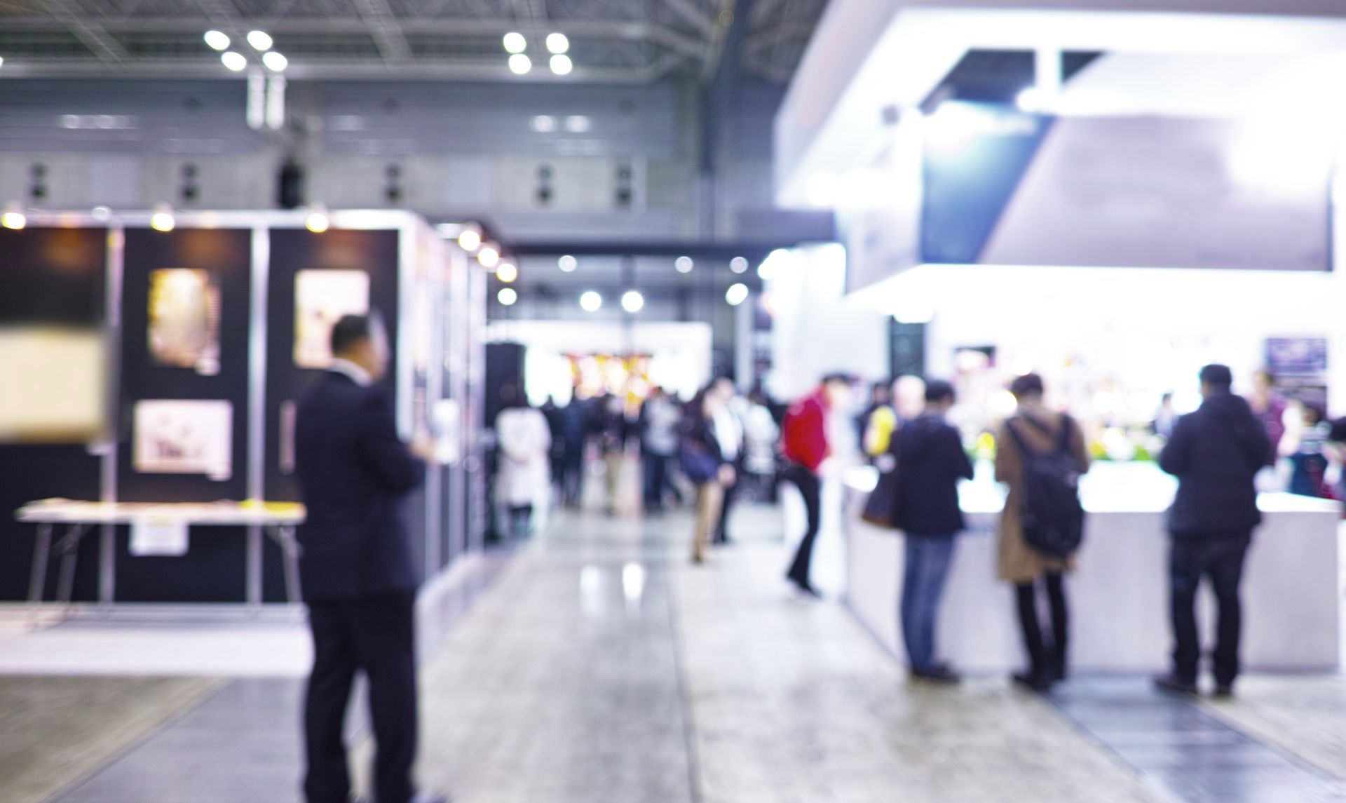 Ein verschwommenes Bild von Menschen, die bei einer Tagung im Flur stehen.