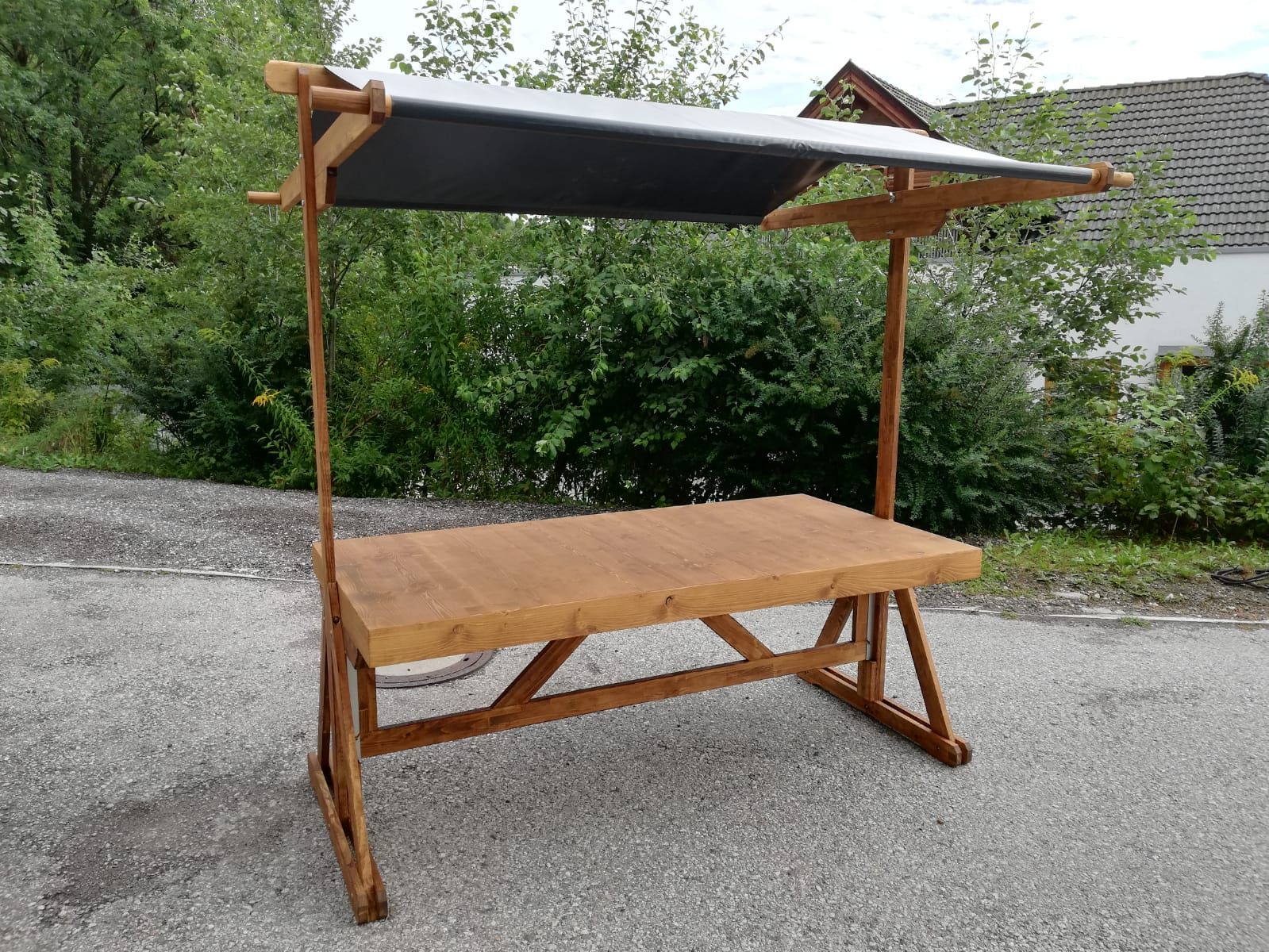 Am Straßenrand steht ein Holztisch mit Baldachin.
