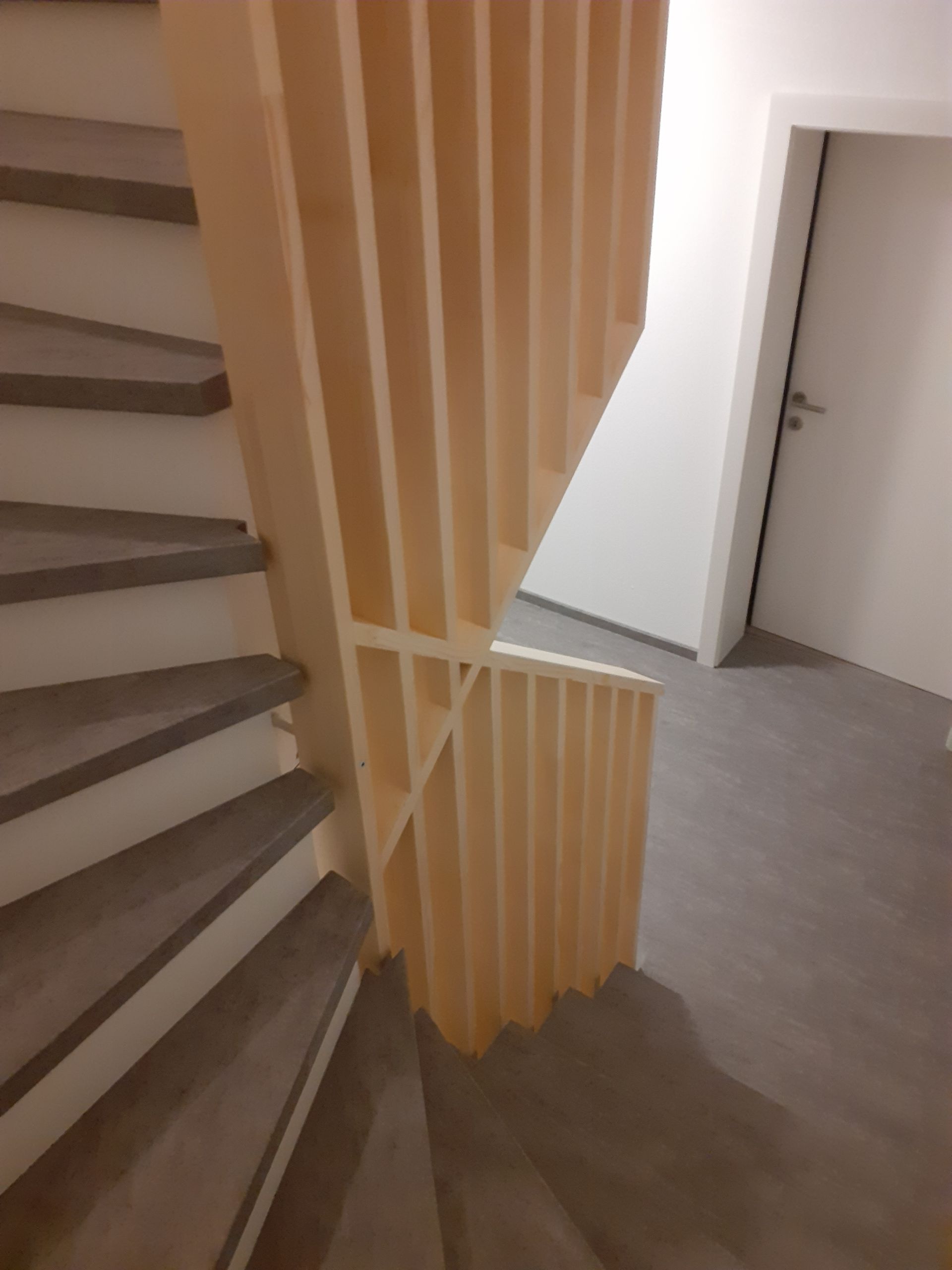 Eine Treppe mit einem Holzgeländer und einer Tür im Hintergrund