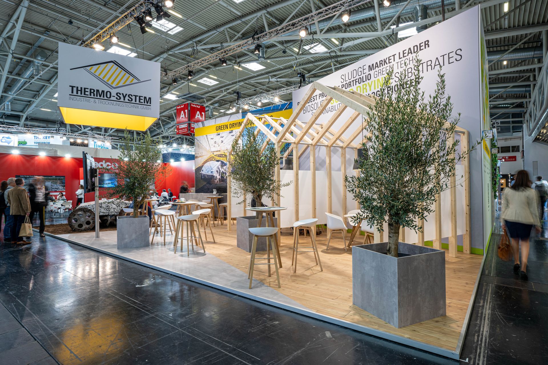 Auf einer Messe steht eine Gruppe von Menschen um einen Stand herum.