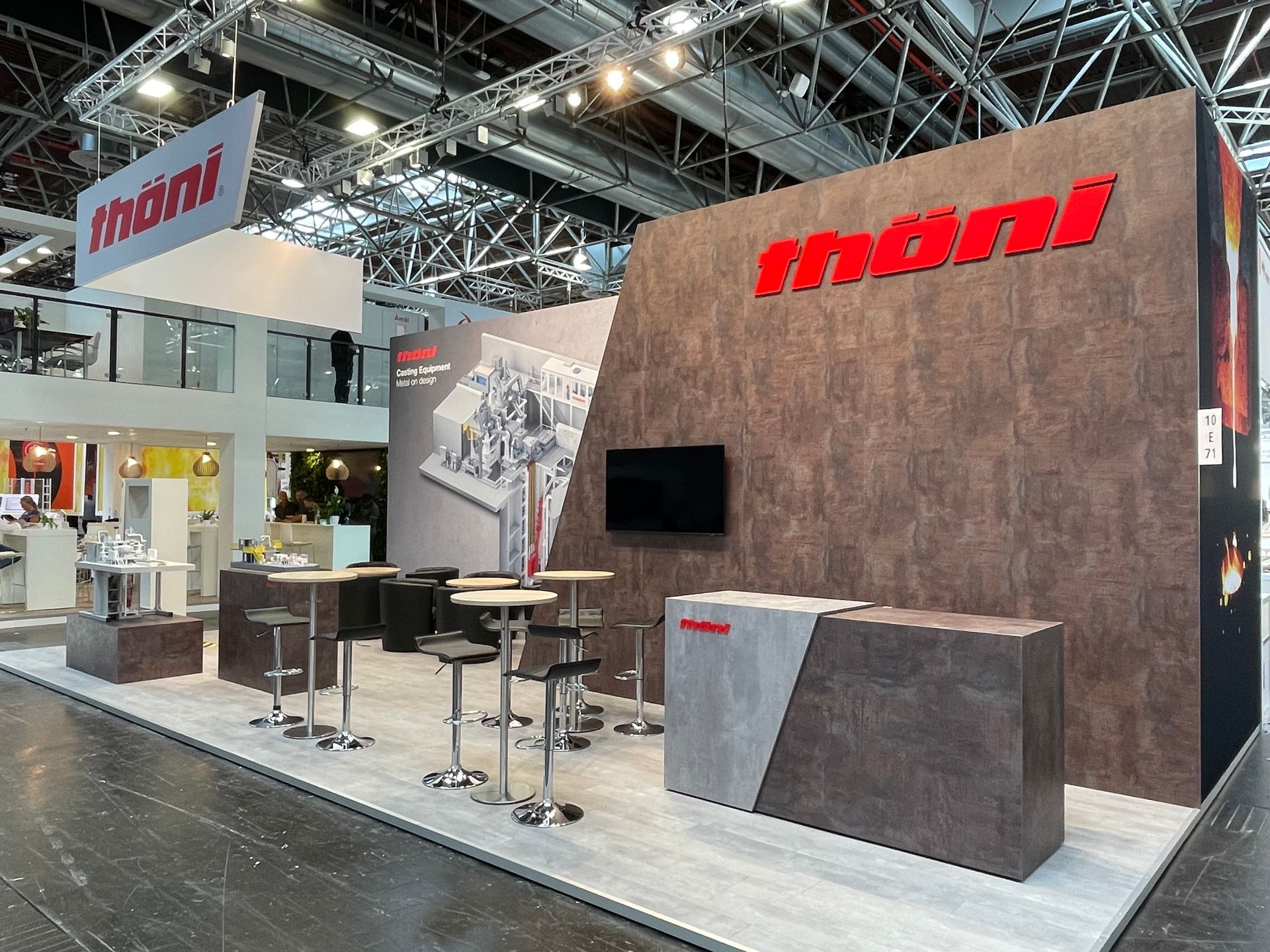 Ein Stand mit Tischen und Stühlen und einem Schild mit der Aufschrift „moni“