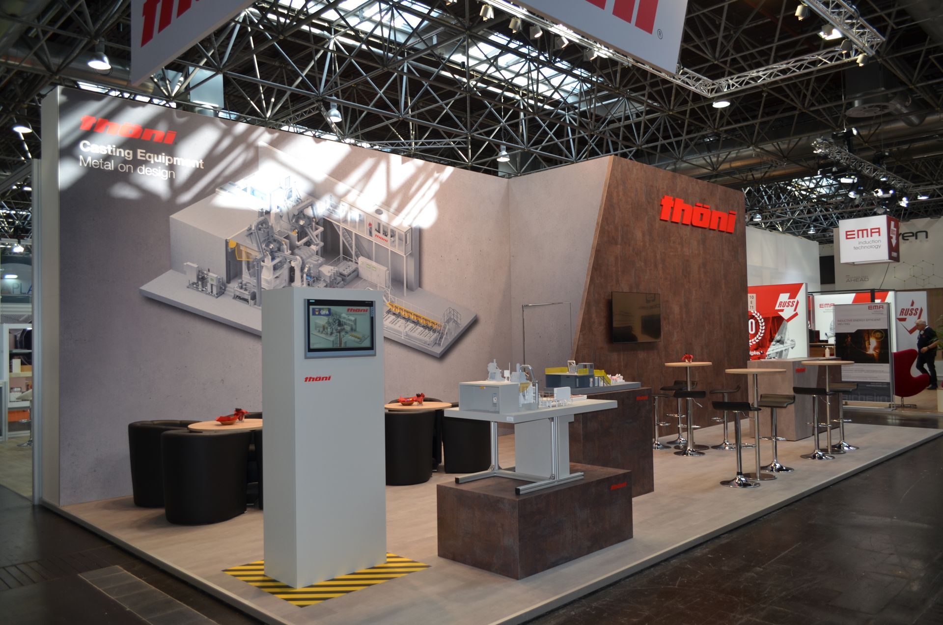 Ein Stand auf einer Tagung mit Tischen und Stühlen
