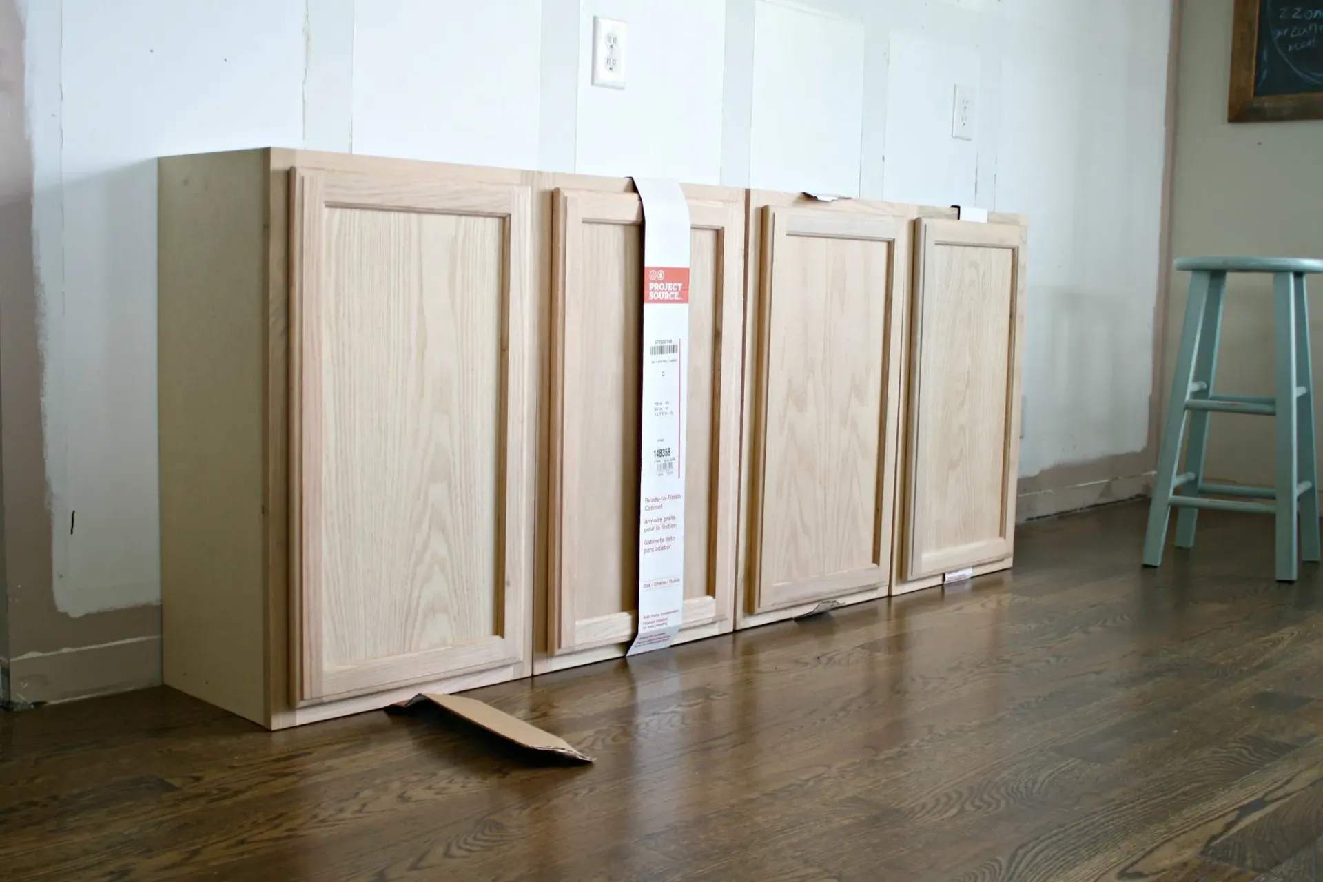 A row of wooden cabinets are sitting on a wooden floor in a room.