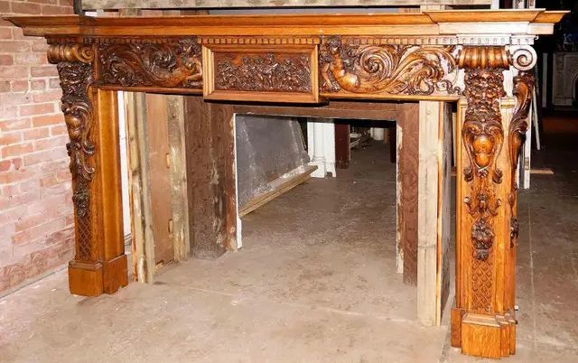 A wooden fireplace mantel is sitting in front of a brick wall.