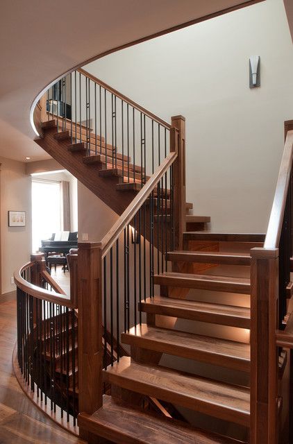 A wooden spiral staircase with a metal railing