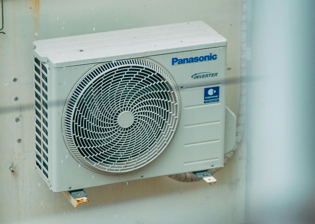 A panasonic air conditioner is mounted on a wall.
