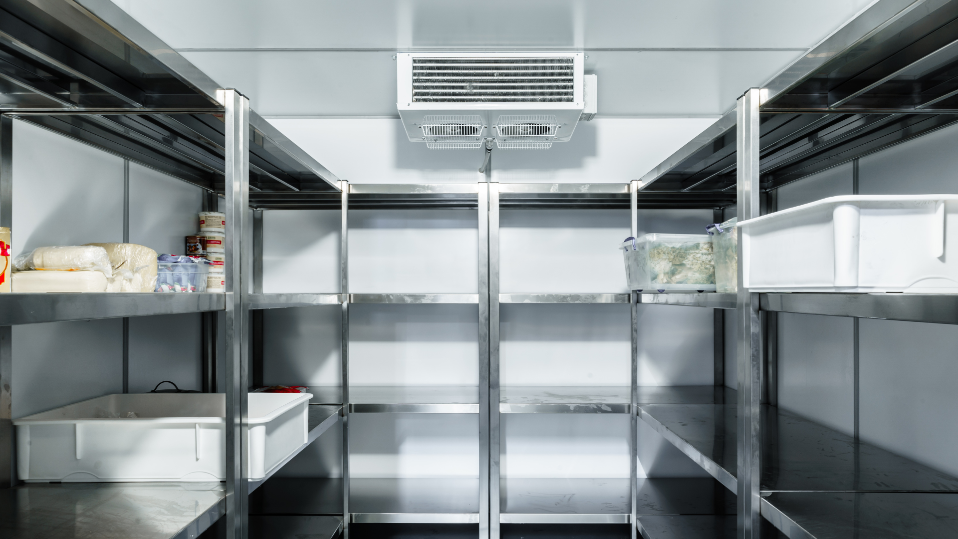 An empty refrigerator with stainless steel shelves in a kitchen.