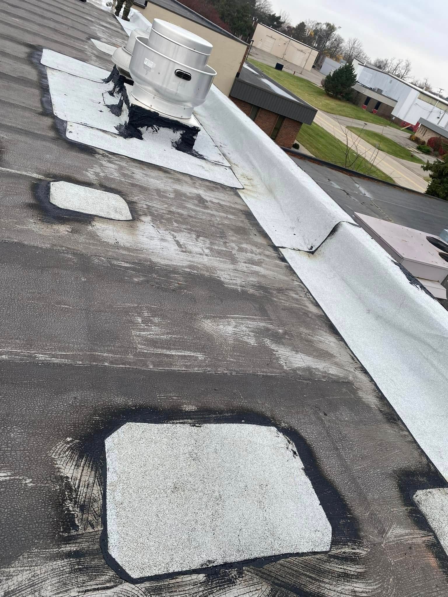 A roof with holes in it and a fan on top of it.