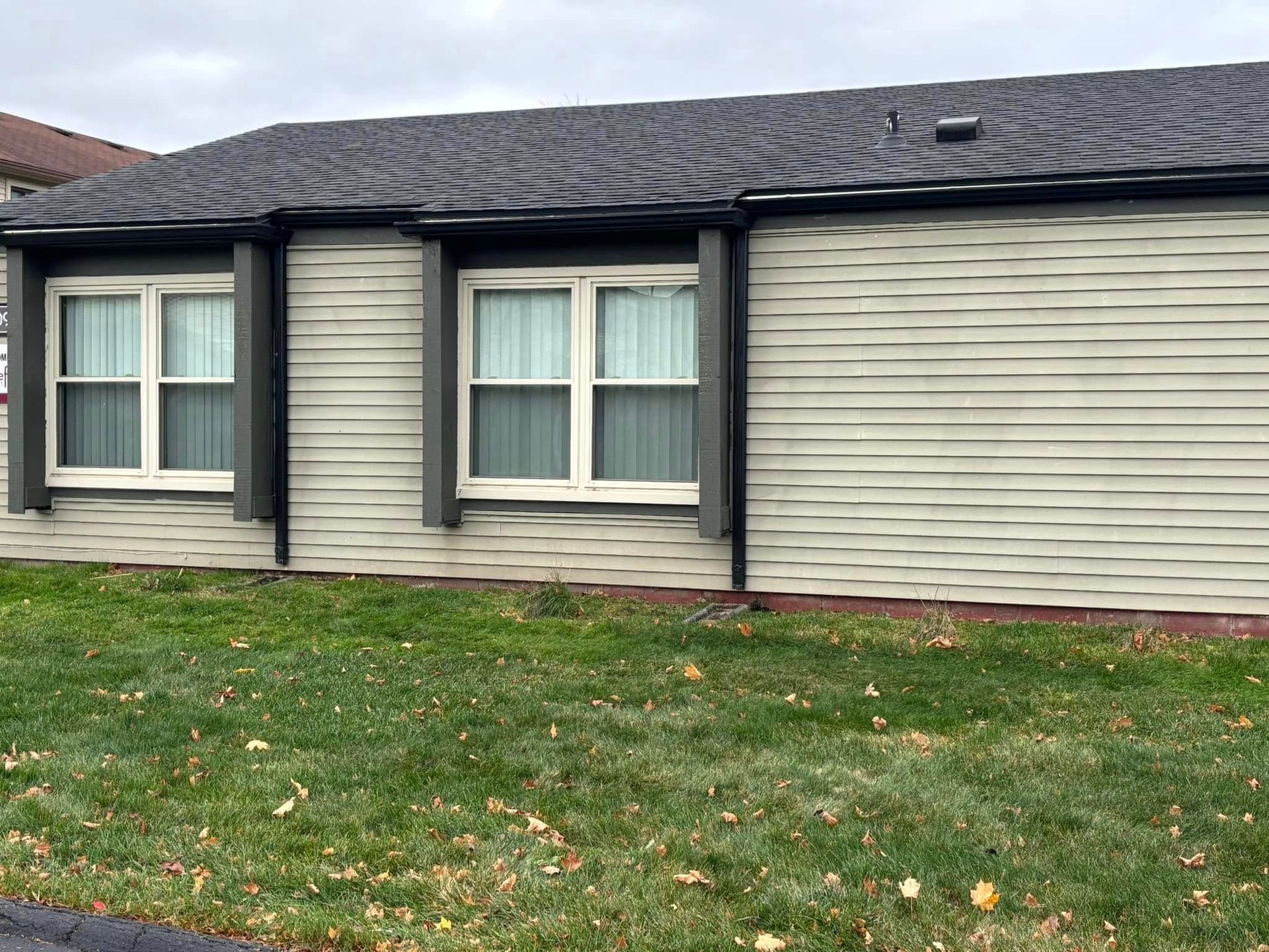 A house with a lot of windows and a lot of grass in front of it.