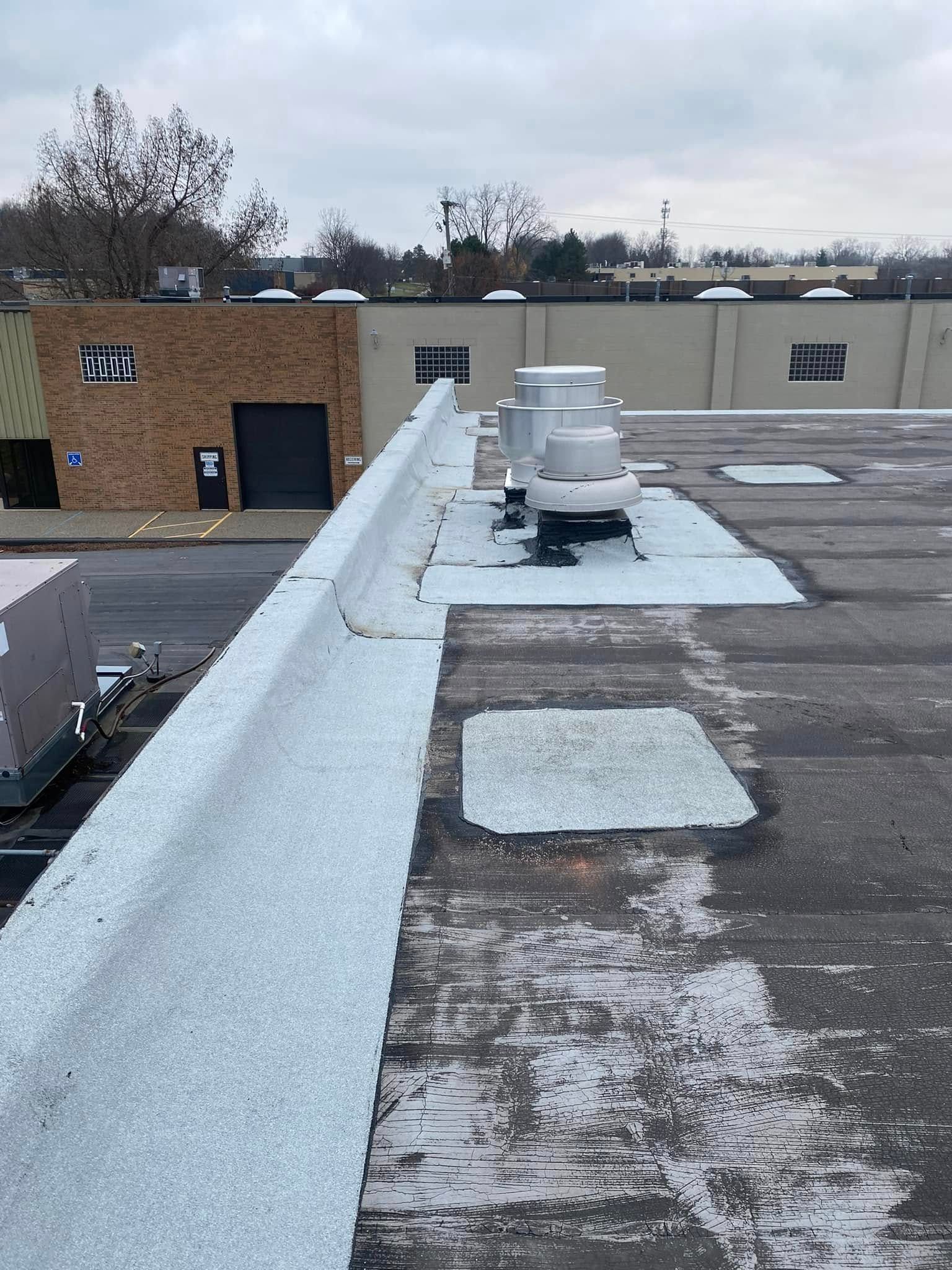 A roof of a building with a brick building in the background.